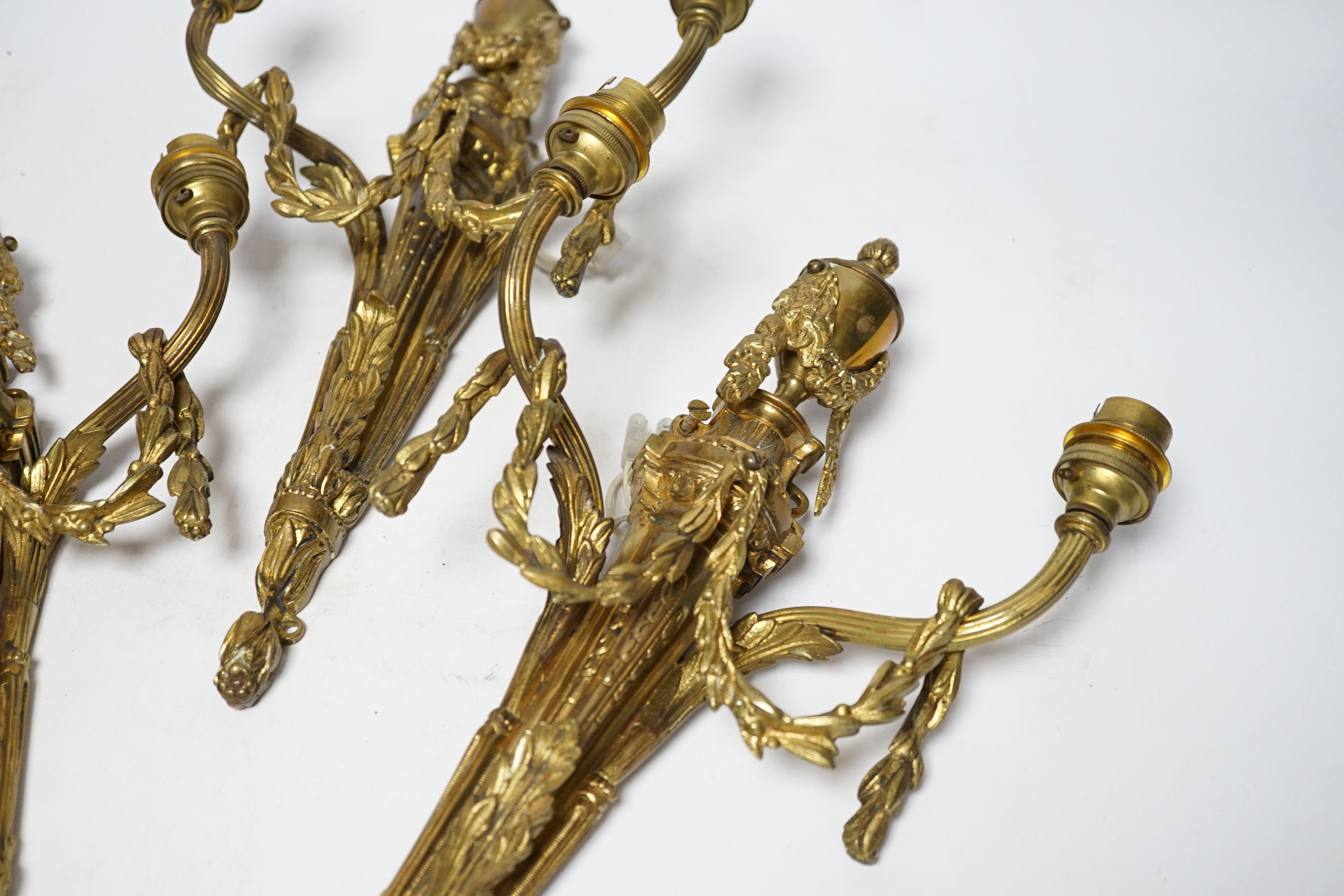 A set of three Louis XVI style two branch ormolu wall lights, 38cm high